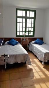 ein Schlafzimmer mit zwei Betten und einem Fenster in der Unterkunft Omae Papagayo in Playa Blanca
