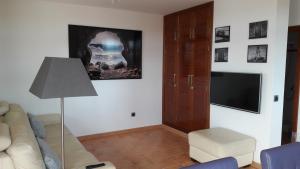 ein Wohnzimmer mit Sofa und Flachbildfernseher in der Unterkunft Omae Papagayo in Playa Blanca