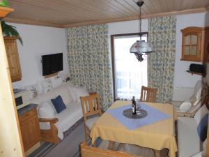 a small living room with a table and a bed at Ferienwohnung Vierthaler in Gosau
