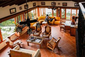 a living room with a lot of furniture and windows at Hotel Zocalo Campestre in Guatapé