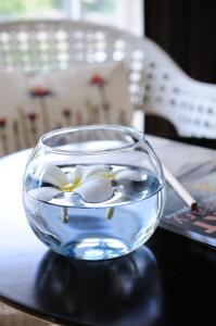 a glass bowl with flowers in it on a table at Kasemsarn Hotel Chanthaburi in Chanthaburi