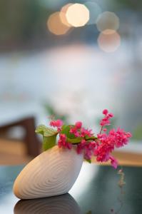 a vase with pink flowers in it on a table at Kasemsarn Hotel Chanthaburi in Chanthaburi