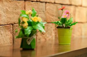 two green vases with flowers on a table at Kasemsarn Hotel Chanthaburi in Chanthaburi
