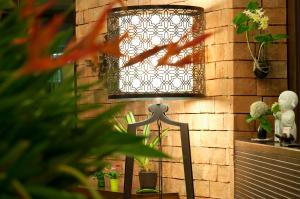 a lamp on a table next to a brick wall at Kasemsarn Hotel Chanthaburi in Chanthaburi