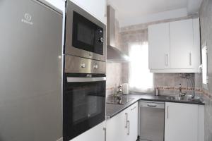a kitchen with a stainless steel oven with a microwave at La Casa de la Alcazaba - Free Parking in Merida