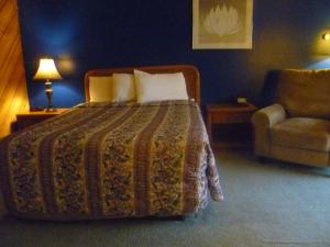 PhillipsにあるTimber Inn Motelのベッドルーム1室(ベッド1台、ソファ、椅子付)