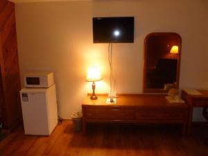 a room with a dresser with a television on the wall at Timber Inn Motel in Phillips