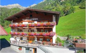 un edificio con flores a un lado. en Haus Alpenglühn, en Längenfeld