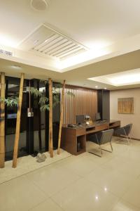 un bureau avec un bureau et des palmiers dans l'établissement Guide Hotel Taipei Bade, à Taipei