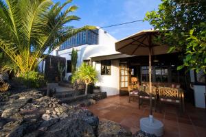 a house with a patio with an umbrella at Casa Teiga in Tahiche