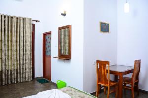 a dining room with a table and a table and chairs at Villa Shanaya in Hikkaduwa