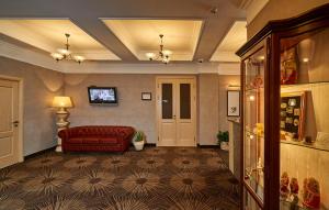 a living room with a red couch and a television at ASTOR Hotel in Perm