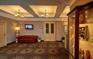 ペルミにあるASTOR Hotelのリビングルーム(赤いソファ、テレビ付)