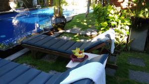 un banc bleu assis à côté d'une piscine dans l'établissement Praschita Bali, à anur