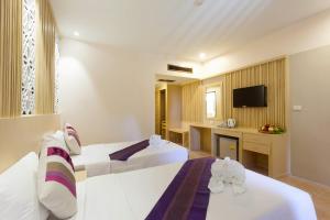 a hotel room with a bed and a dresser at Patong Lodge Hotel - SHA Extra Plus in Patong Beach
