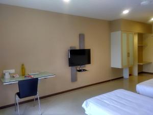 a bedroom with a desk and a tv on the wall at Villa Park in Mysore