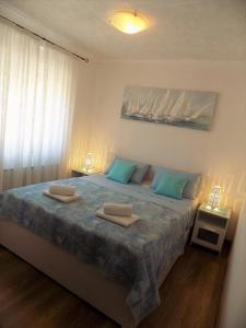 a bedroom with a bed with two towels on it at Apartment Anamarija in Njivice