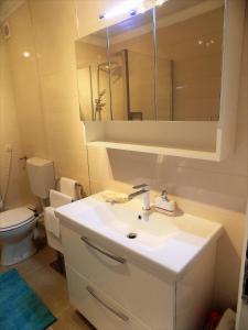 a bathroom with a sink and a toilet and a mirror at Apartment Anamarija in Njivice +20 photos