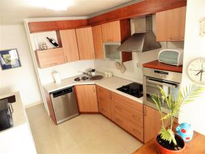a small kitchen with wooden cabinets and a sink at Apartment Anamarija in Njivice