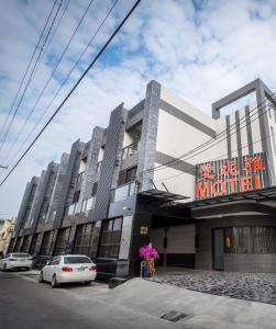 un edificio con coches estacionados frente a él en Ai Ni Ya Motel, en Beigang