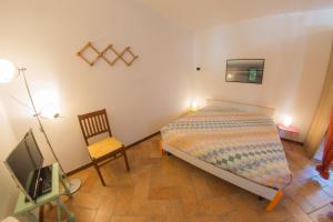1 dormitorio con 1 cama, 1 silla y TV en A due passi dal Botteniga en Treviso