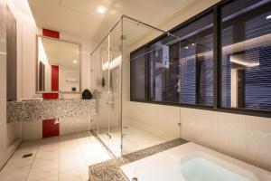 a bathroom with a tub and a glass shower at Ai Ni Ya Motel in Beigang