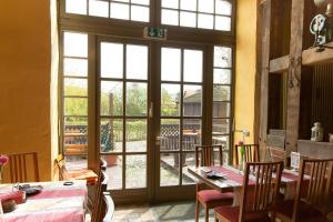 a room with a large glass door with tables and chairs at Landhotel Zur Scheune in Röbel