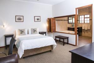 a bedroom with a bed and a bathroom with a mirror at Queen Manor Boutique Guest House in Graaff-Reinet +40 photos