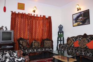 a living room with two couches and a tv at Nachis BNB in Bangalore