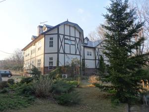 a large house with a tree in front of it at Gasthof Arutany in Nasu