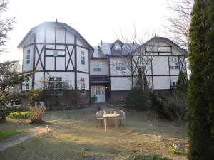 a large white house with a table in front of it at Gasthof Arutany in Nasu