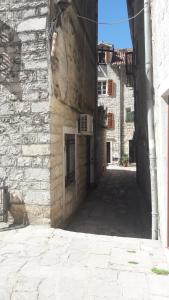 an alley with a stone wall and a building at Apartment VASSA in Kotor