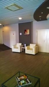 una stanza con due sedie e un tavolo in una stanza di Ambassador Suites Antwerp ad Anversa