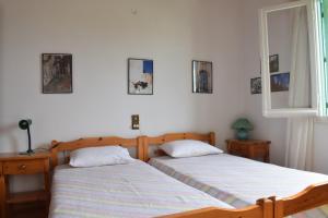 dwa łóżka siedzące obok siebie w sypialni w obiekcie Nafsika's House w mieście Votsi
