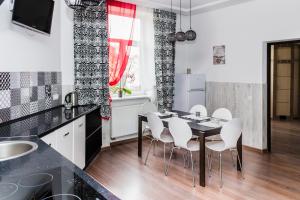 kuchnia ze stołem i białymi krzesłami w obiekcie Apartments Zefir w Lwowie