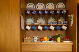a kitchen with plates and cups on a shelf at The Burrow at Wombat Bend in Dixons Creek