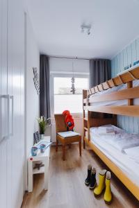 a bedroom with a bunk bed and a chair and shoes at Zuhause am Meer in Büsum