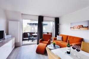 a living room with an orange couch and a table at Zuhause am Meer in Büsum