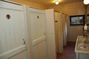 baño con lavabo, aseo y puerta en Maison de la Vallee en Purnode