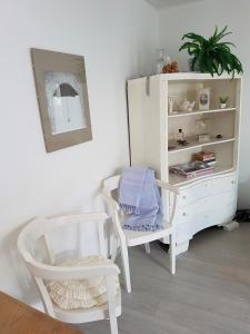マリ・ロシニにあるLa Casa Di Nonnaの椅子2脚と白いキャビネットのある部屋