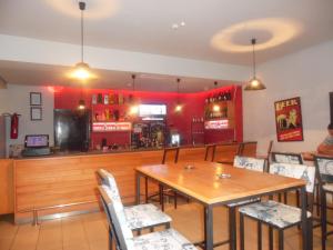 um restaurante com mesa e cadeiras e um bar em Hotel El Fell em Hammamet