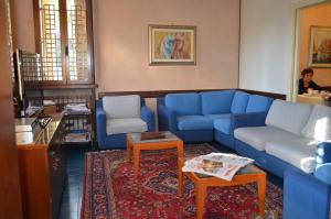 a living room with a blue couch and two chairs at Hotel Magnolia in Preganziol