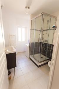 a bathroom with a glass shower and a sink at Appartement spacieux Rochereau in LʼIsle-sur-la-Sorgue