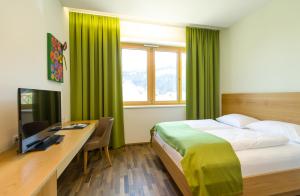um quarto com uma cama e uma secretária com um computador em Business Motel Feldkirch em Feldkirch