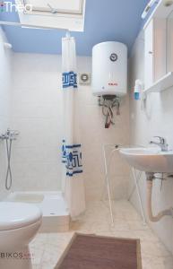 a bathroom with a white toilet and a sink at Sofia Apartments in Alexandroupoli +46 photos
