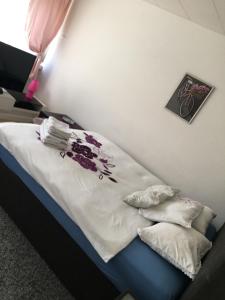 ein Schlafzimmer mit einem Bett mit weißer Bettwäsche und Blumen in der Unterkunft Apartments in Bern - Apartment Lila in Bern