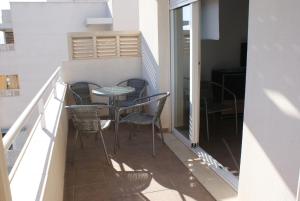 balkon ze stołem i krzesłami w budynku w obiekcie Golf y playa junto al Cabo de Gata w mieście Almería
