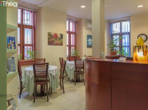 a dining room with tables and chairs and windows at Sofia Apartments in Alexandroupoli