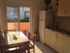 a kitchen with a table and chairs and a refrigerator at Sunny Rock Volme Apartments in Banjole
