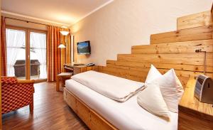 a hotel room with a large bed and a desk at Landhaus Sonnenbichl Mittenwald in Mittenwald